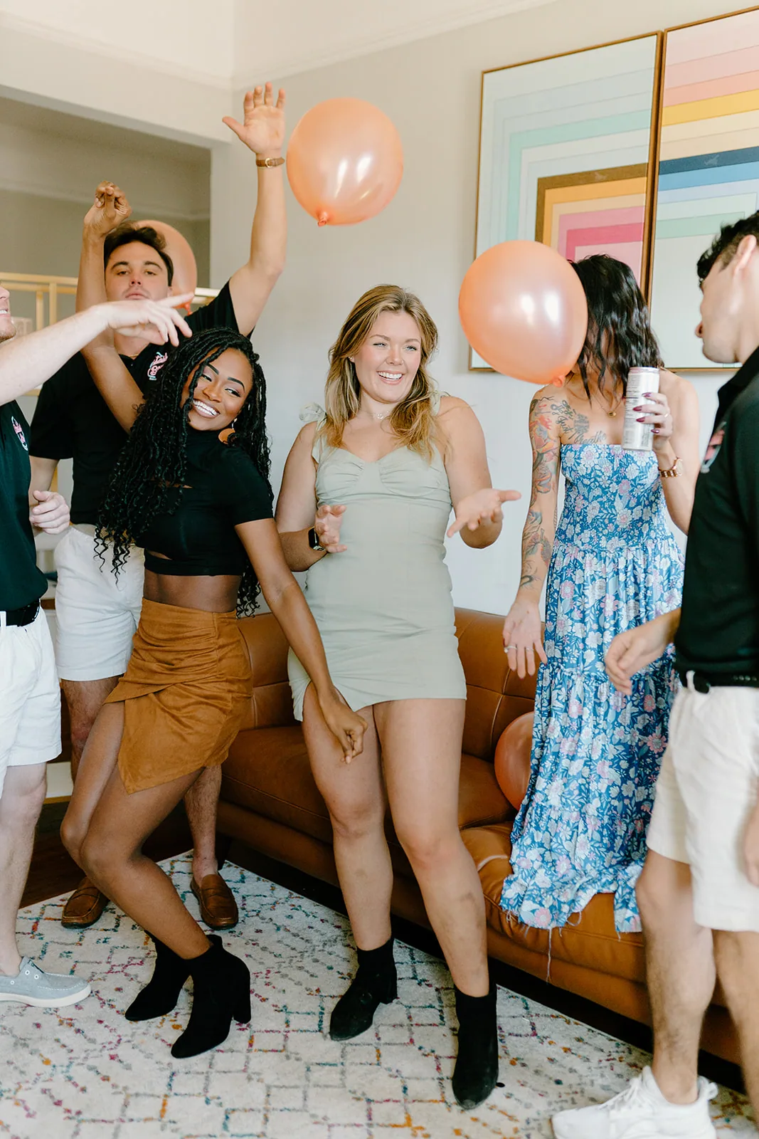 Woman in a blue floral dress laughing and celebrating at an indoor bachelorette event
