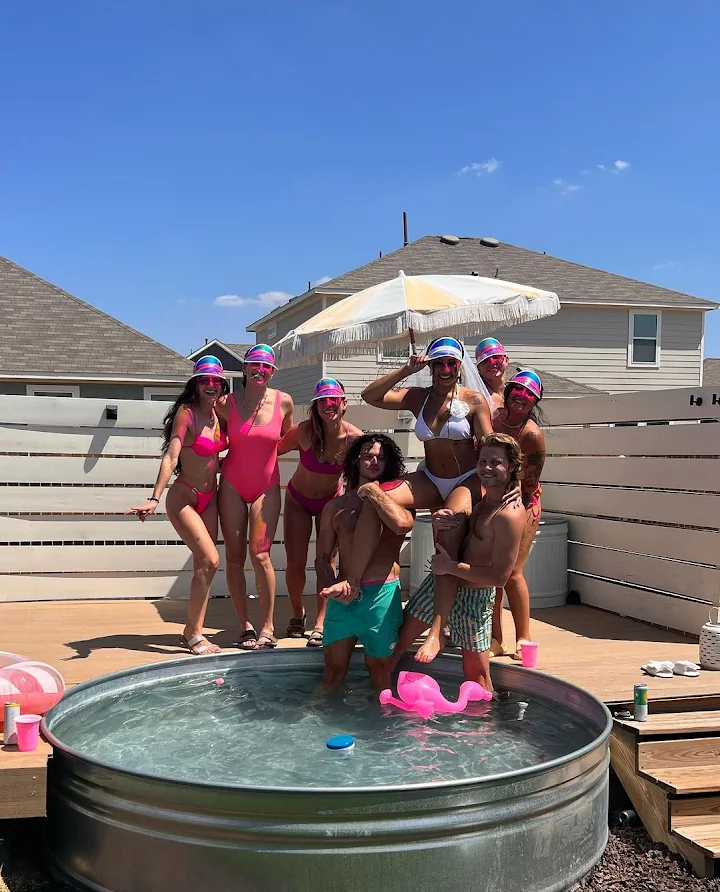 a group of people standing next to a swimming pool