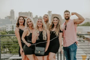Group of women in black outfits posing together at a nighttime event