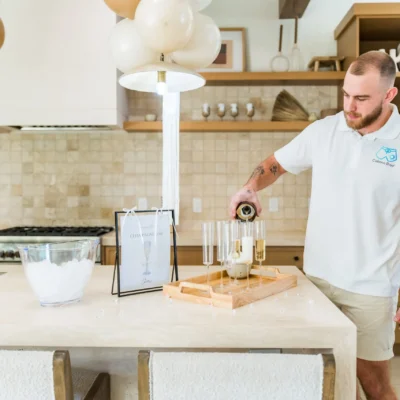 A Cabana Boys host setting up glassware and supplies on a kitchen counter for a party