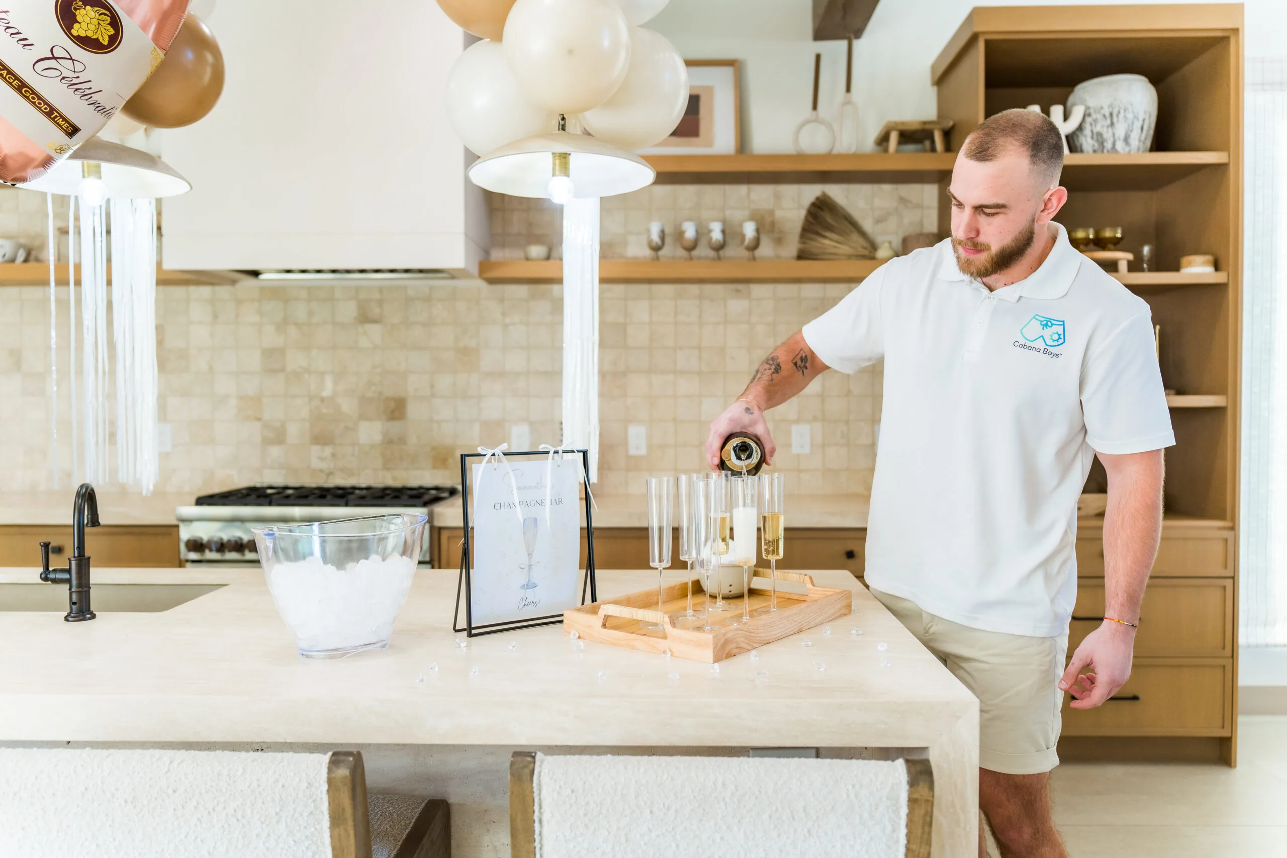 A Cabana Boys host setting up glassware and supplies on a kitchen counter for a party
