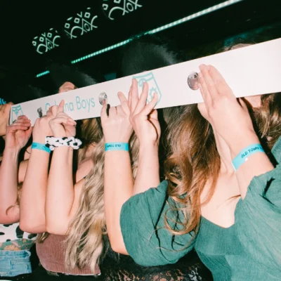 A group of women with hands raised celebrating inside a decorated party bus