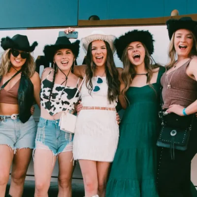 A Cabana Boys host posing with a group of women in front of a teal party bus