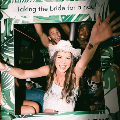 A Cabana Boys host and a bachelorette group celebrating inside a party bus with a "Taking the bride for a ride" sign